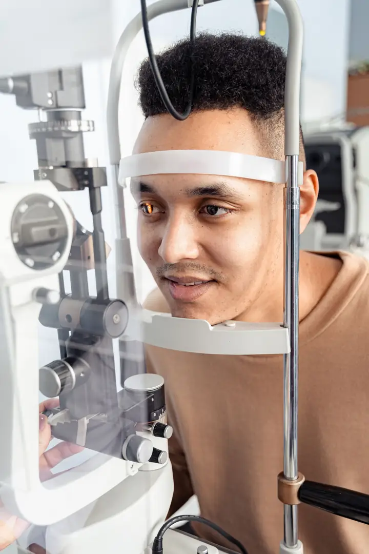 Patient resting his chin on a slit lamp during an eye examination
