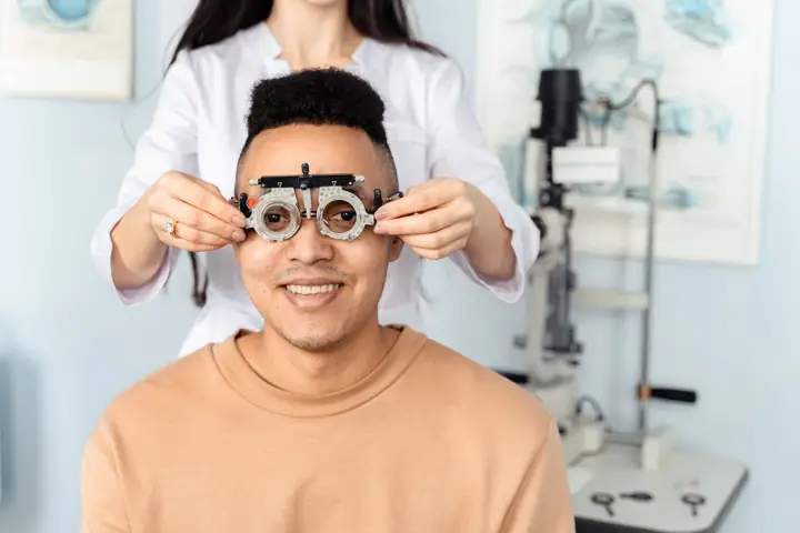 Smiling patient wearing a trial frame during an eye test
