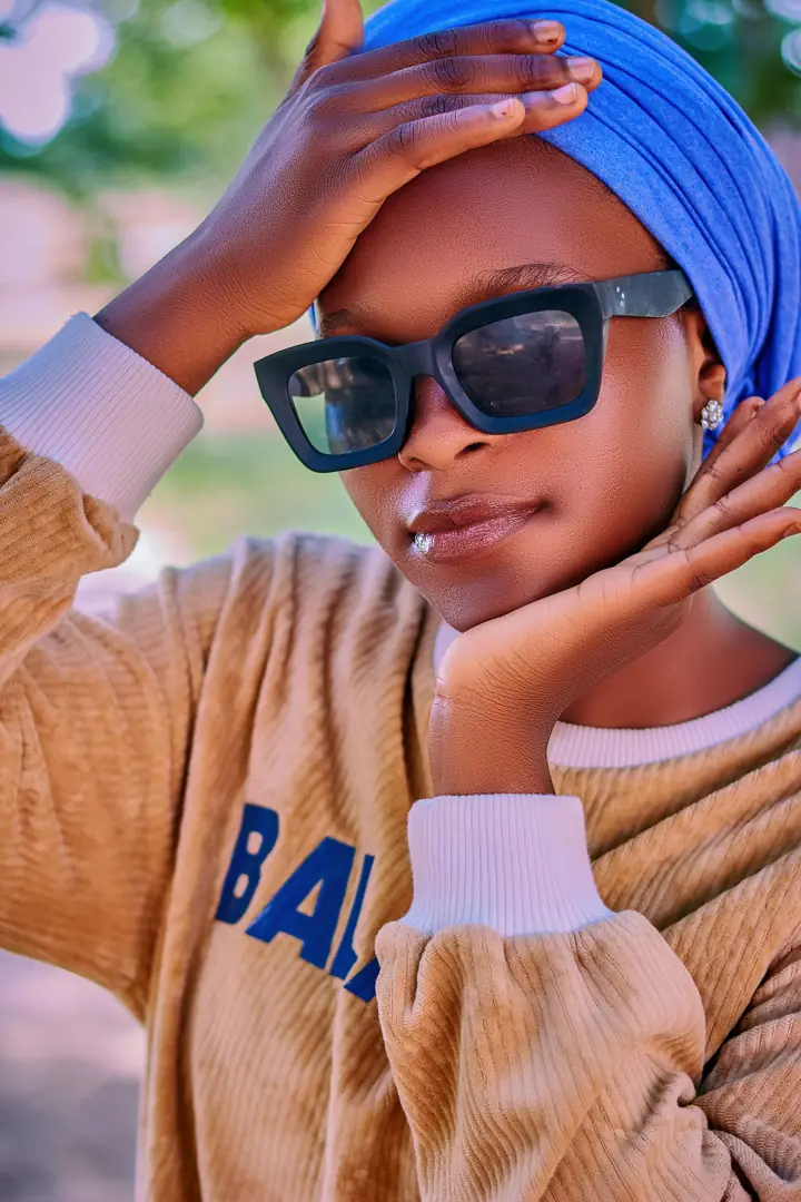 Woman in a blue headwrap wearing square sunglasses